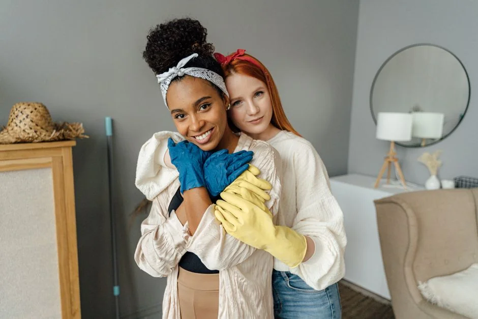 services-05 a-woman-in-a-green-shirt-and-black-gloves-vacuuming-a-gray-ottoman-5txz228u4eo